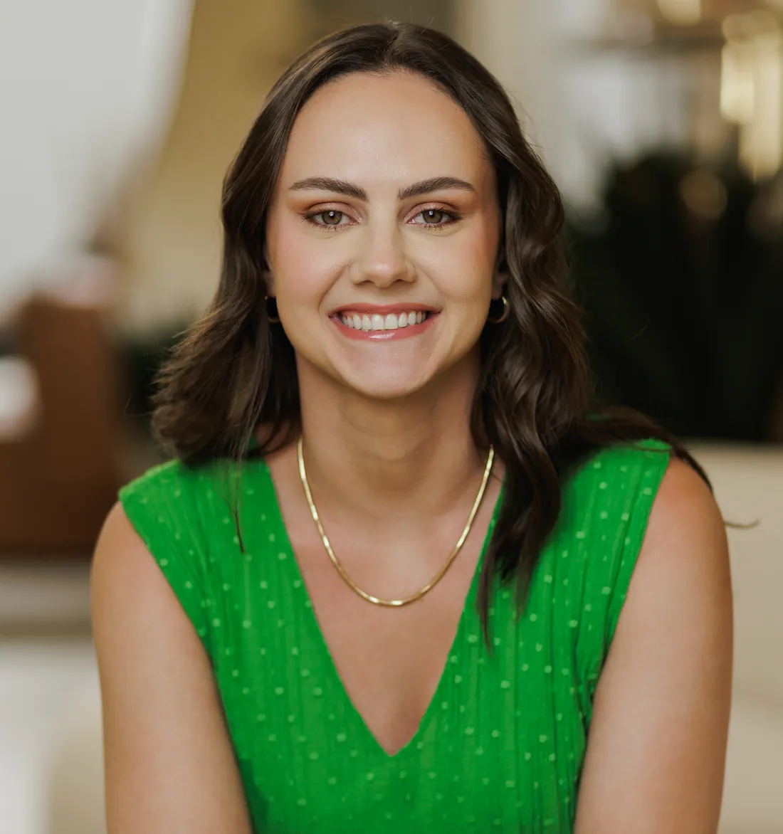 Dra. Larissa Basmage sorrindo, de vestido verde e colar dourado